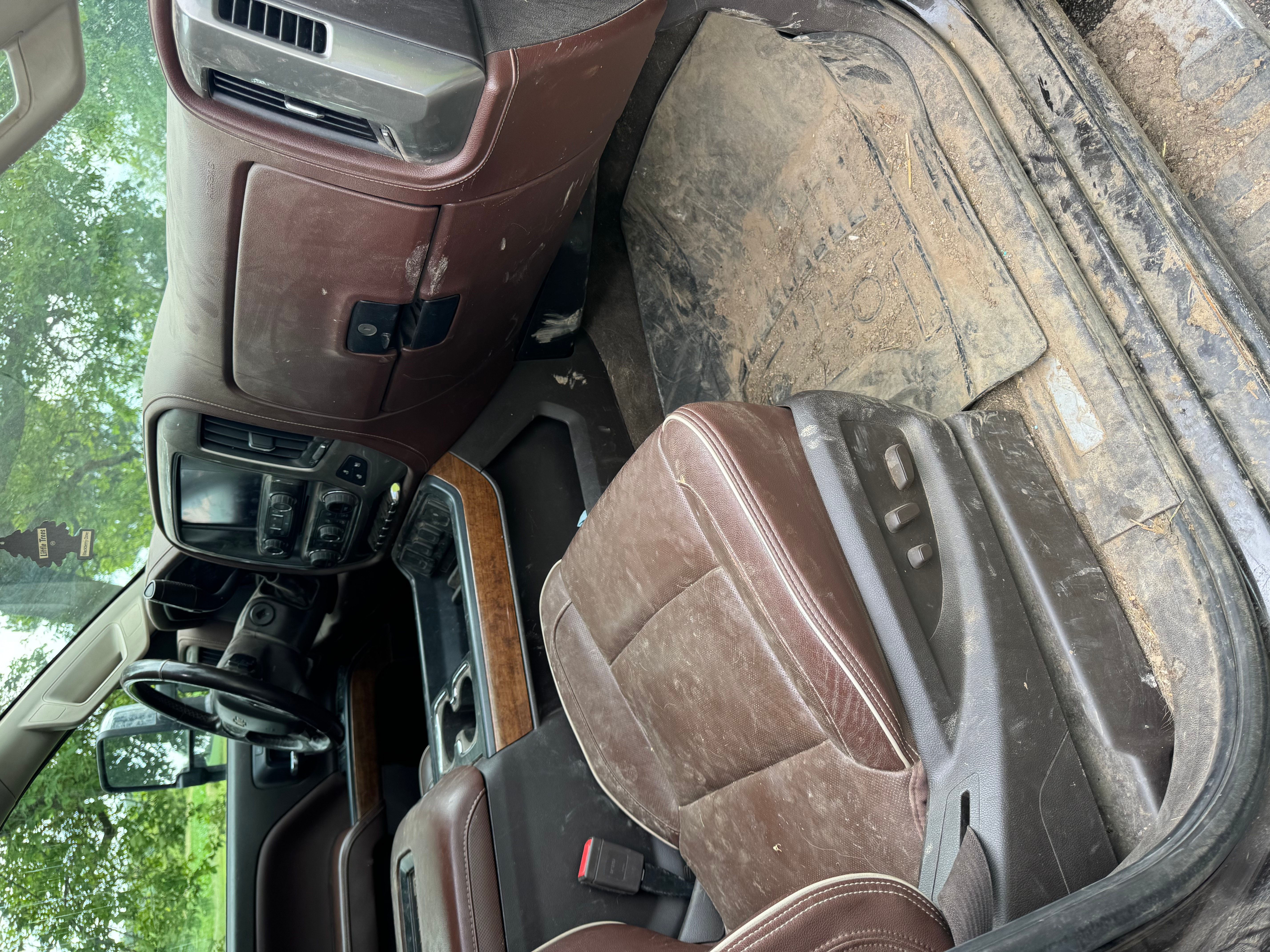 Heavily-worn brown King Ranch leather interior — faded, dirt-streaked seats and a soiled driver's footwell. The kind of cabin condition that knocks thousands off a trade-in appraisal.