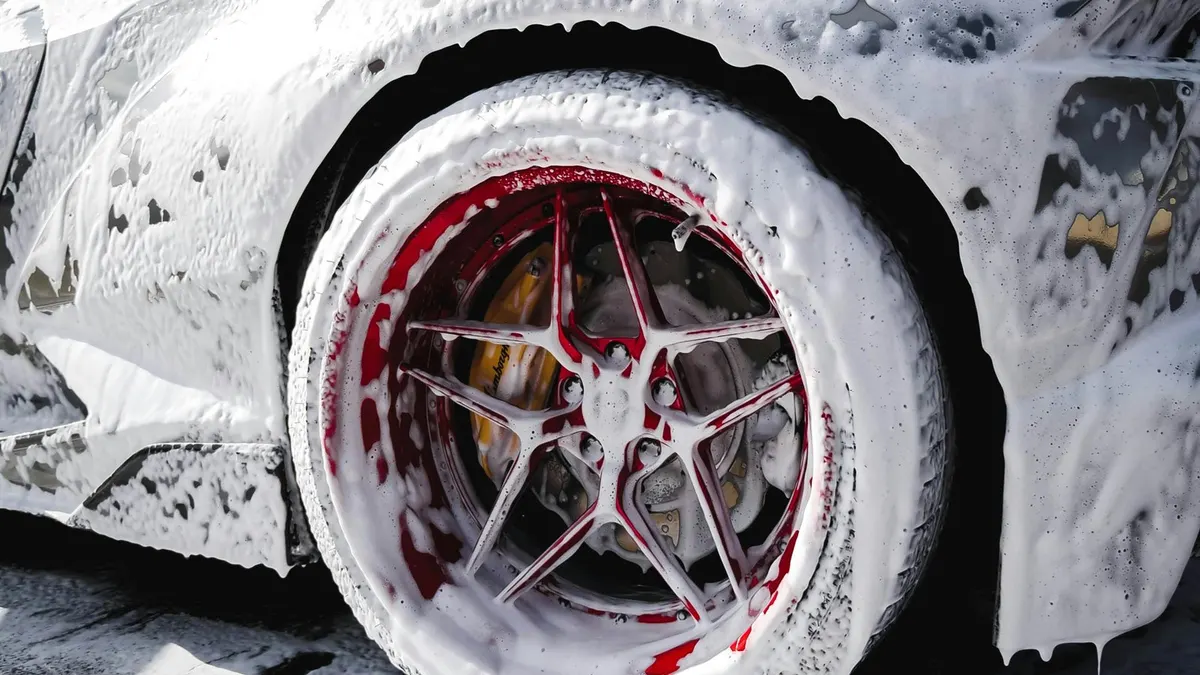 Exotic sports car wheel being foam-washed during a full detail by After Hours Car Detailing in Mid-Michigan