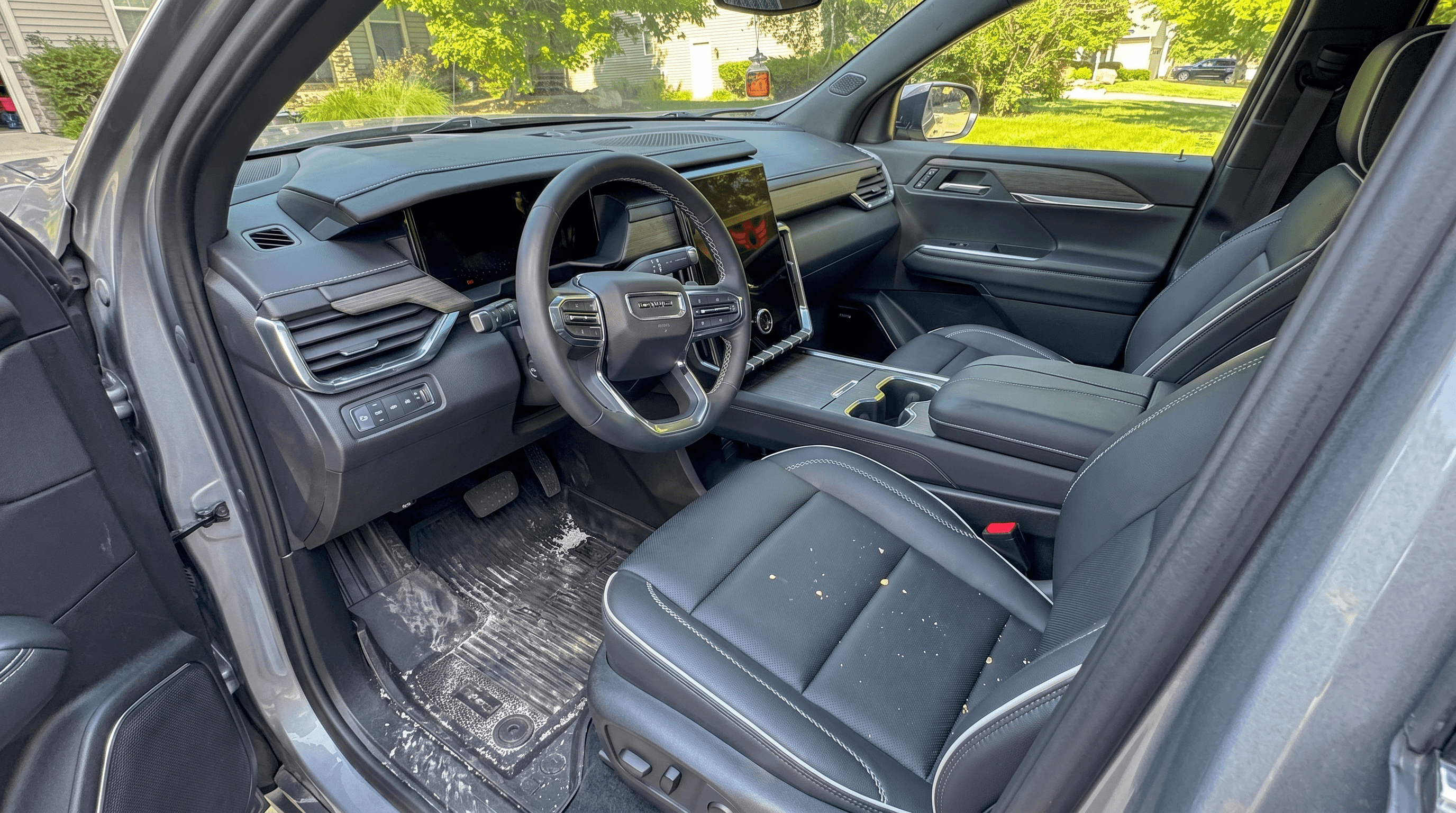 Salt-stained WeatherTech floor mat in a Chevrolet Equinox driver's footwell — gritty winter sand and dried road salt collected in the channels. The Mid-Michigan reality every cabin lives with.